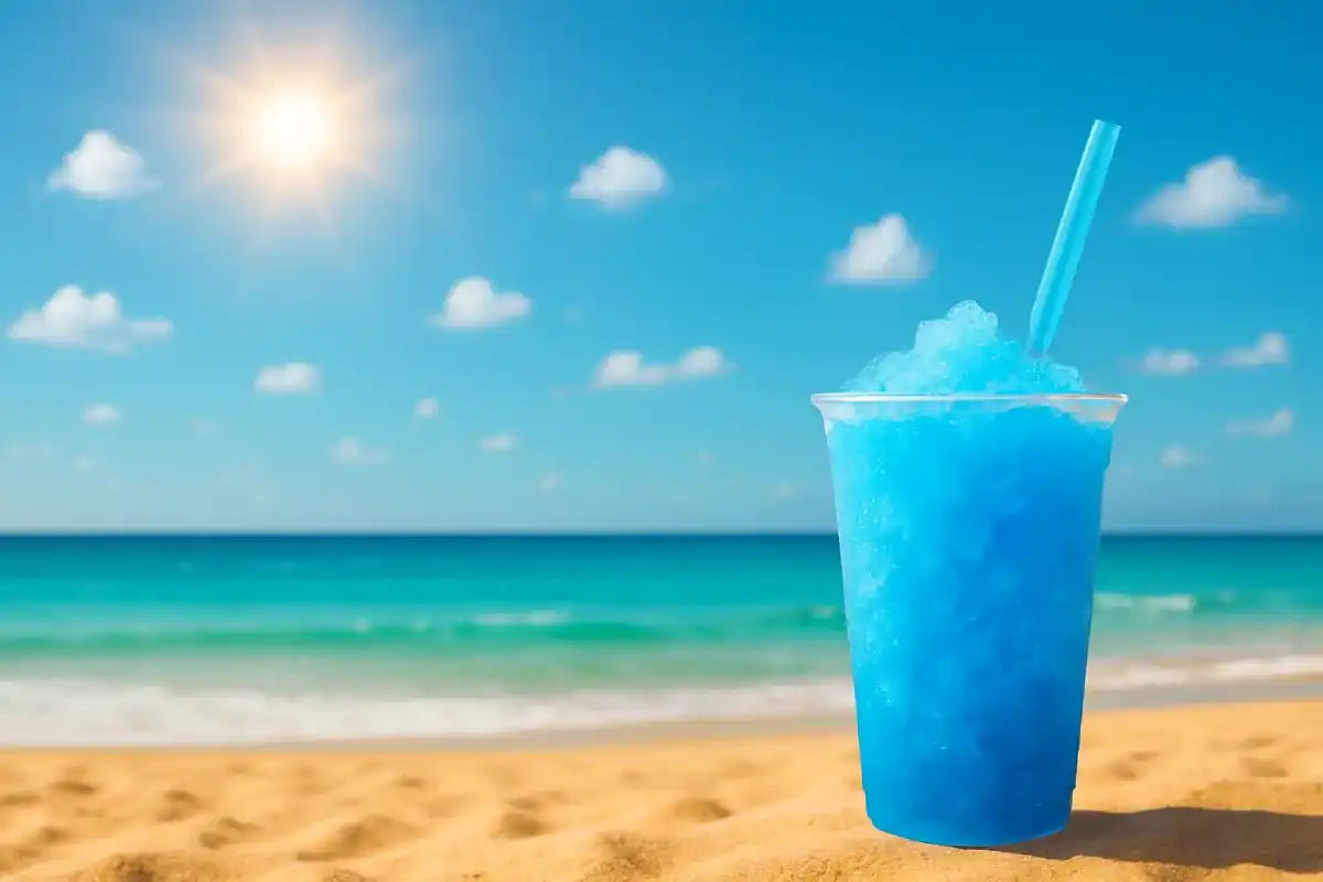 Gobelet de Produit à Granita Bleu Lagon posé sur le sable