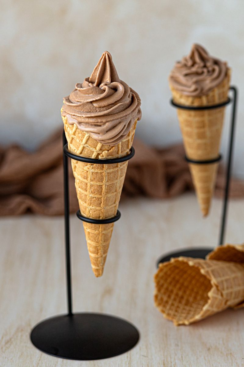 Glace italienne au chocolat en cornet sur un support noir élégant.