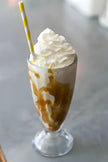 Milkshake caramel on Mix Neutre Sundae avec crème fouettée et paille rayée jaune